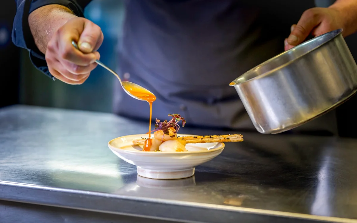 Chef plating a dish for a La Marina dinner cruise